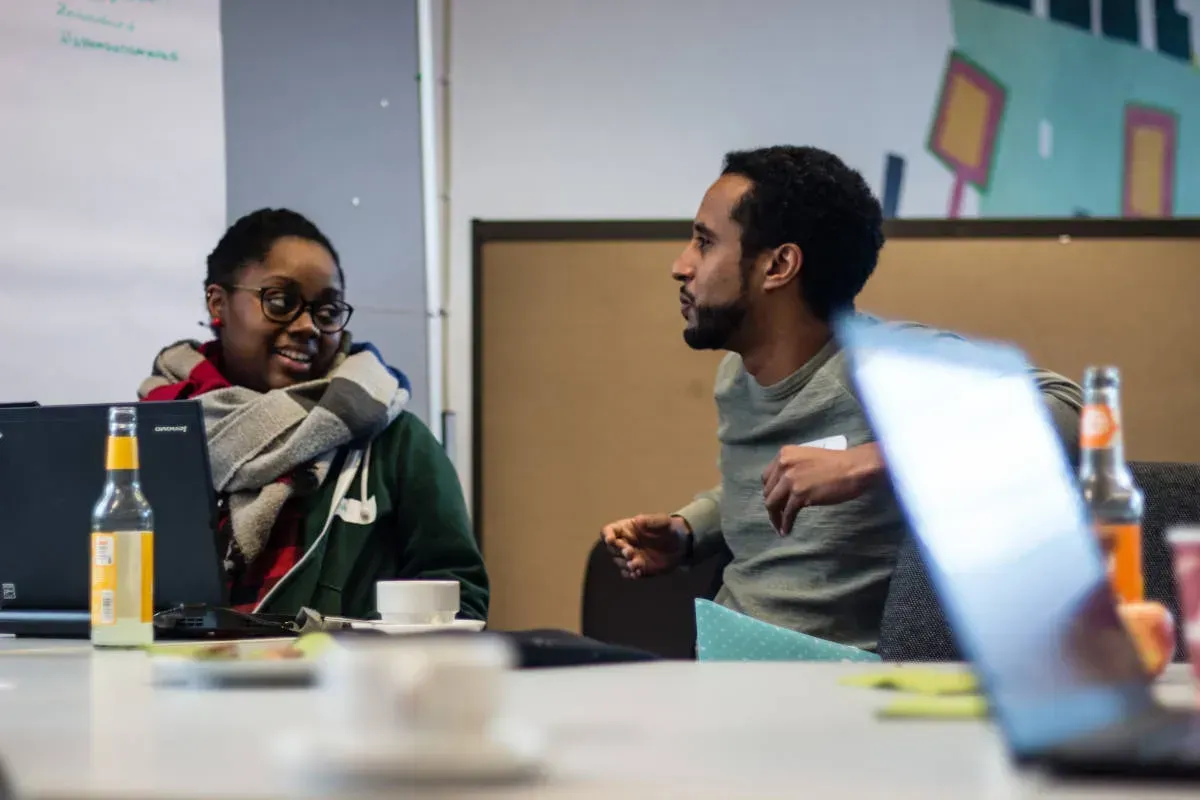 Zwei Personen sitzen an einem Tisch und unterhalten sich.