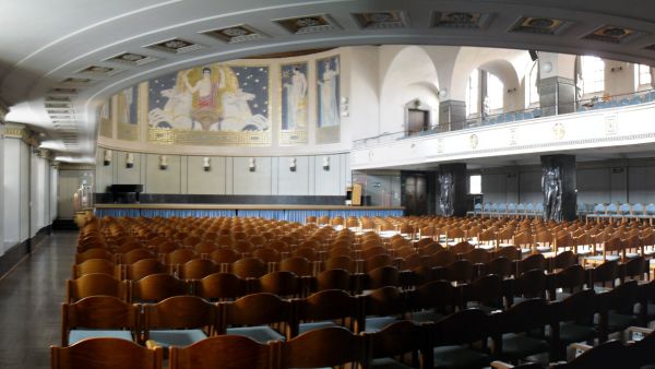 A large, round, seated hall in the Art Nouveau style with raised tiers and a stage.