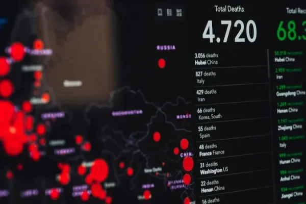 Photo of a dashboard showing Covid data. On the left, it shows a bubble map from Europe. On the right, there are two columns, one with deaths and one with the number of recovered people in different cities. The total number of deaths displayed is 4720.